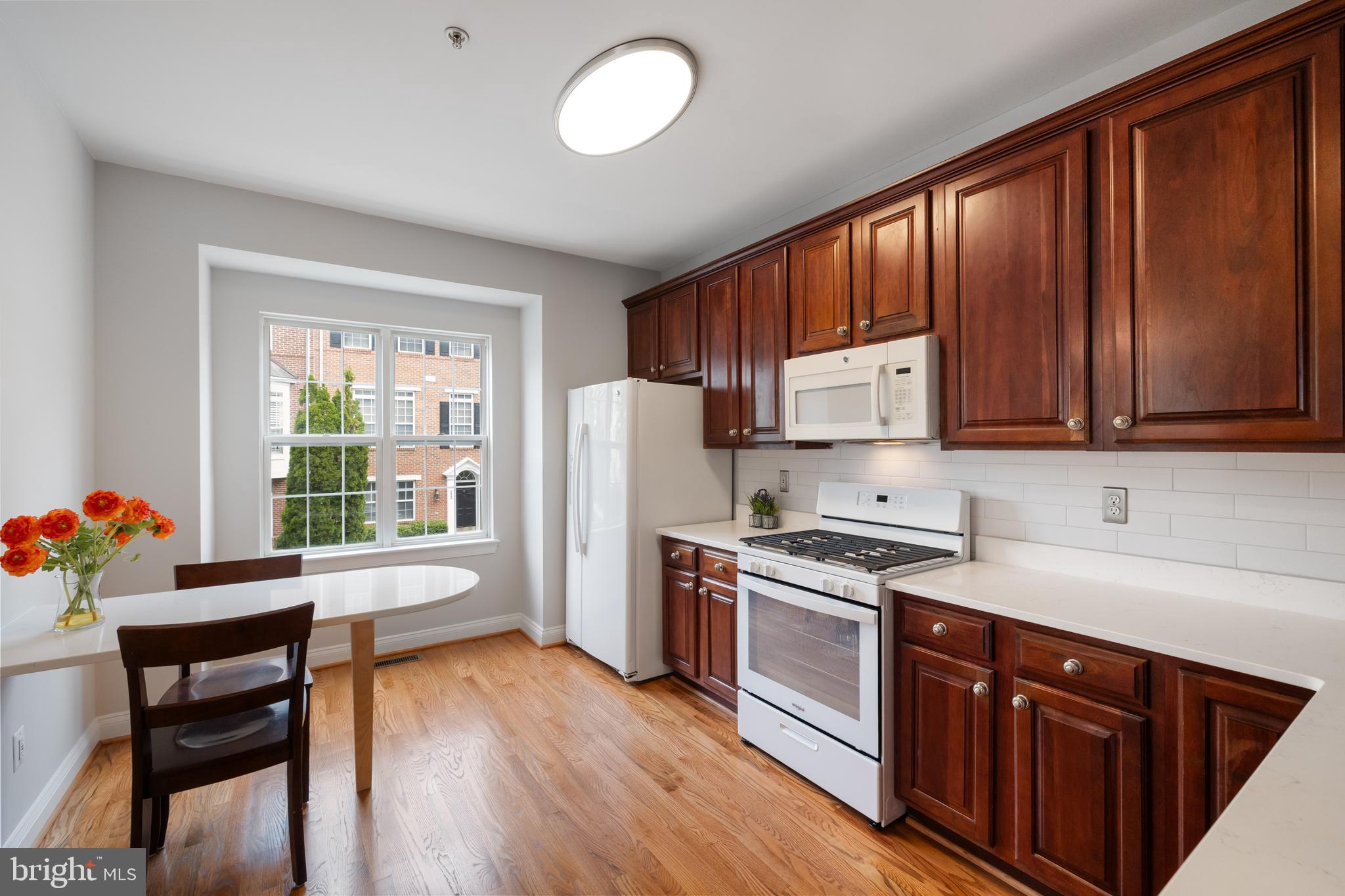 5117 Grimm Drive Alexandria, VA 22304 - Photo 18 of 67 a kitchen with stainless steel appliances granite countertop a refrigerator a sink dishwasher a stove and white countertops with wooden floor