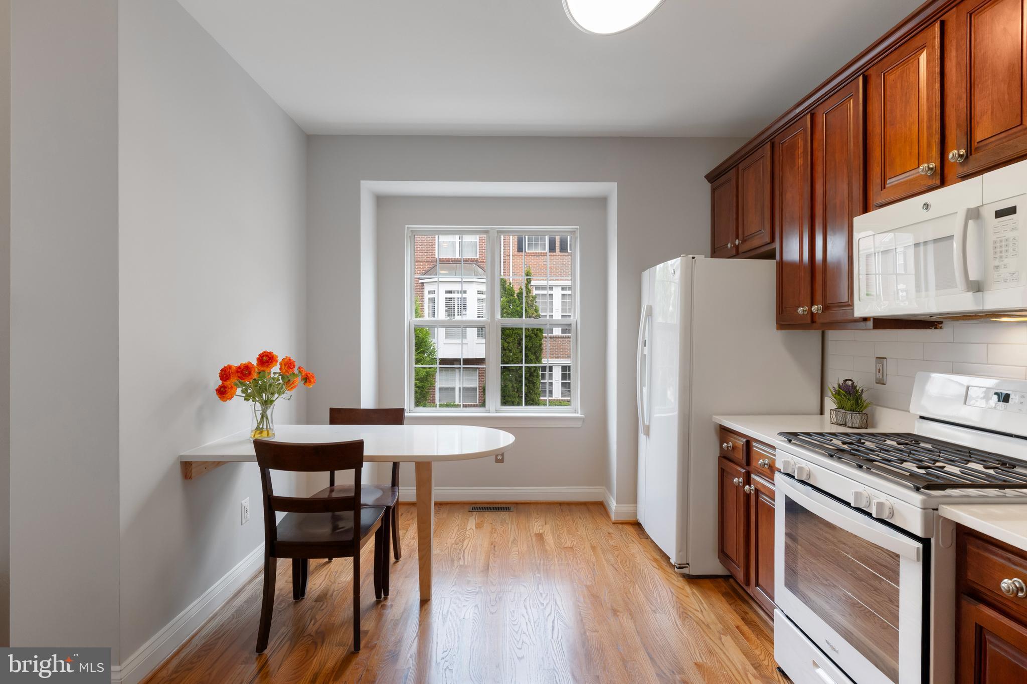 5117 Grimm Drive Alexandria, VA 22304 - Photo 19 of 67 a kitchen with stainless steel appliances granite countertop a stove top oven a refrigerator and a dining table with wooden floor