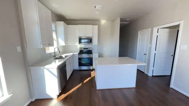 a large kitchen with a wooden floor and a large window