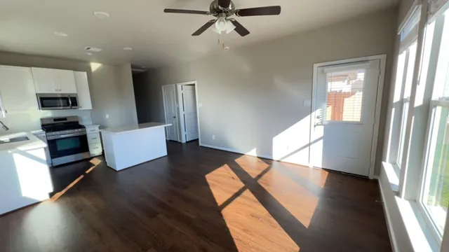 a view of a living room with furniture and wooden floor