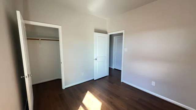 an empty room with wooden floor and closet