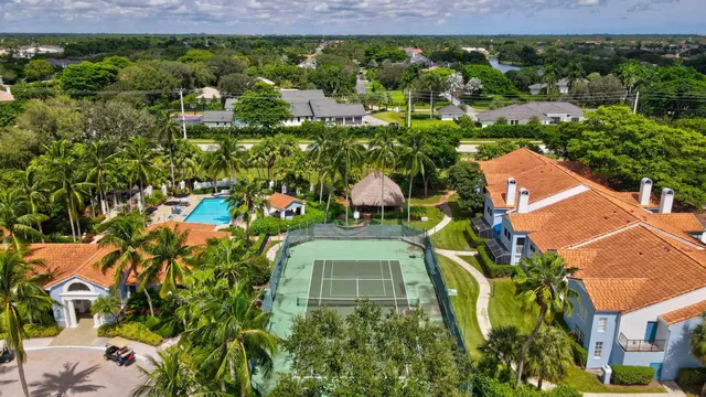 an aerial view of residential houses with outdoor space and trees