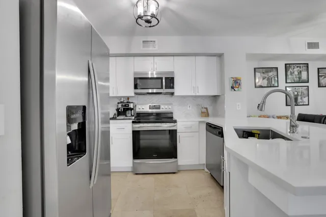 a kitchen with stainless steel appliances a stove microwave and a refrigerator