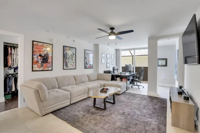 a living room with furniture a large window and a flat screen tv