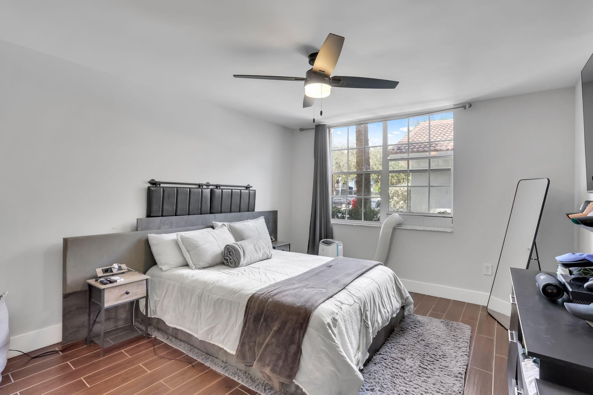 3237 Clint Moore Road, Unit 103 Boca Raton, FL 33496 - Photo 6 of 13 a bedroom with a bed and wooden floor