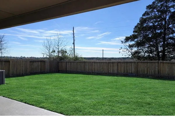 a view of a backyard with wooden fence
