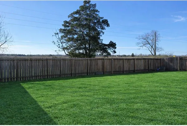 a view of a backyard with wooden fence