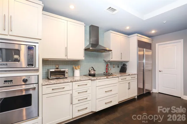 a kitchen with stainless steel appliances white cabinets and a refrigerator