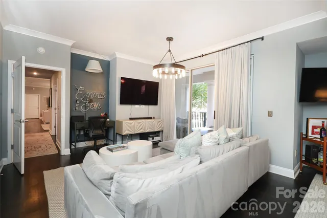 a living room with furniture a flat screen tv and a large window