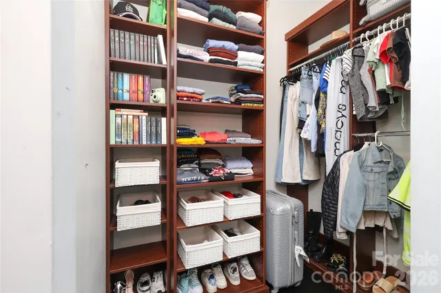 a view of walk in closet with clothes and shoes