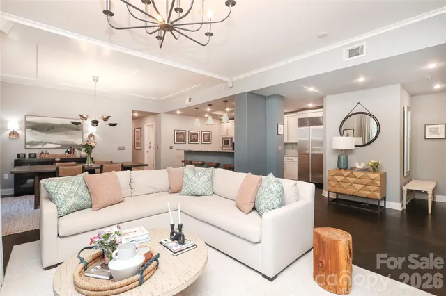a living room with furniture kitchen view and a window