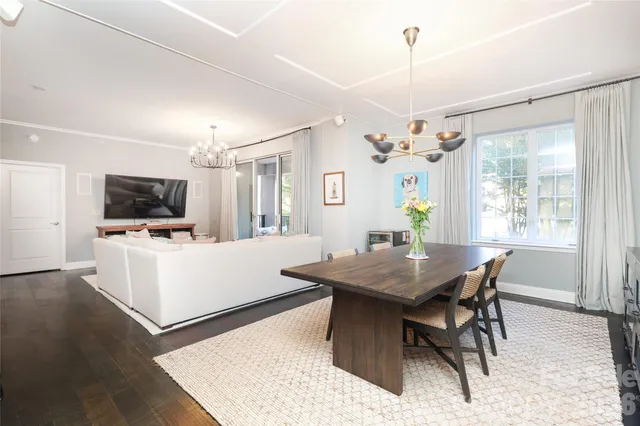 a living room with dining table and a flat screen tv