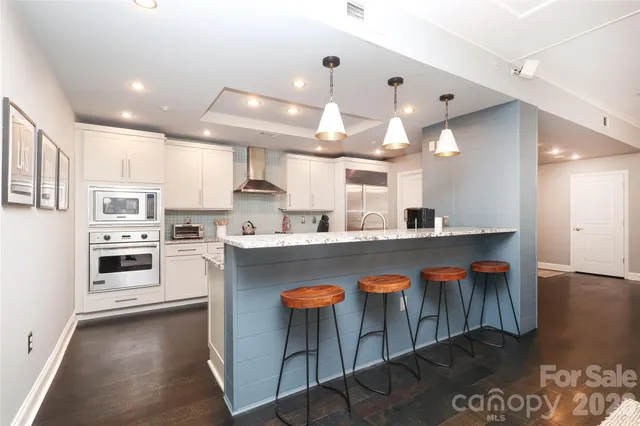 a kitchen with stainless steel appliances granite countertop a stove a sink a refrigerator and a microwave