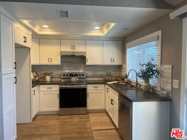 a kitchen with stainless steel appliances granite countertop a stove sink and cabinets