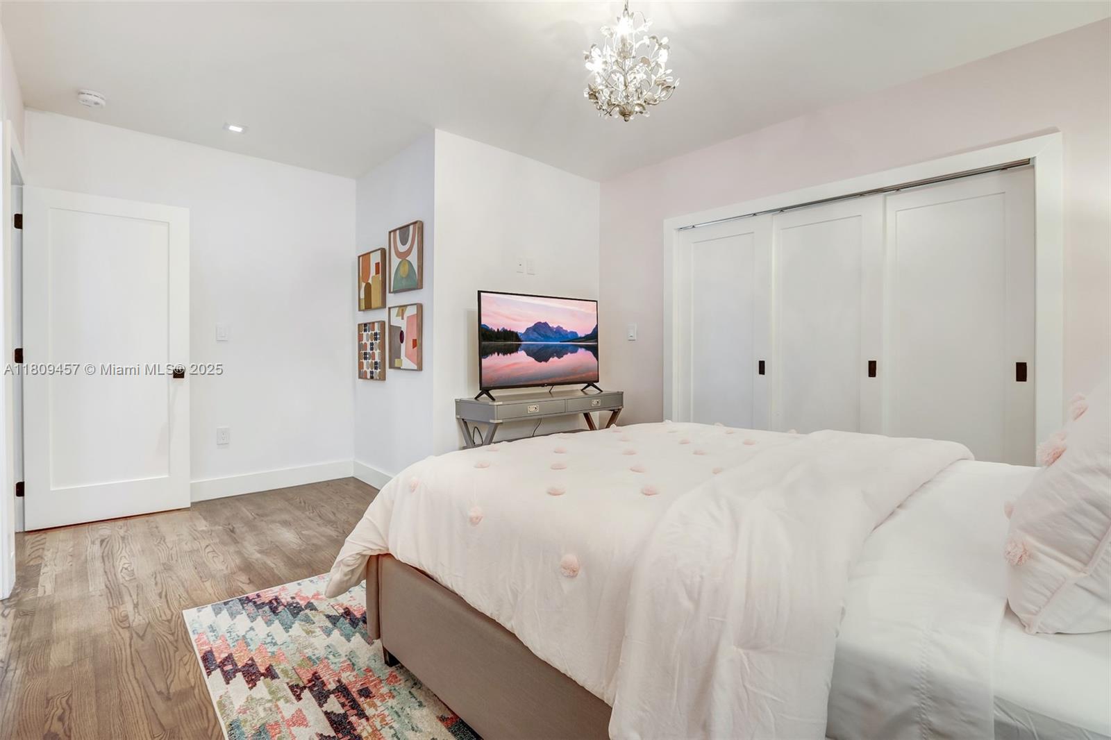 555 Southwest 27th Road Miami, FL 33129 - Photo 22 of 26 a bedroom with a bed and a chandelier