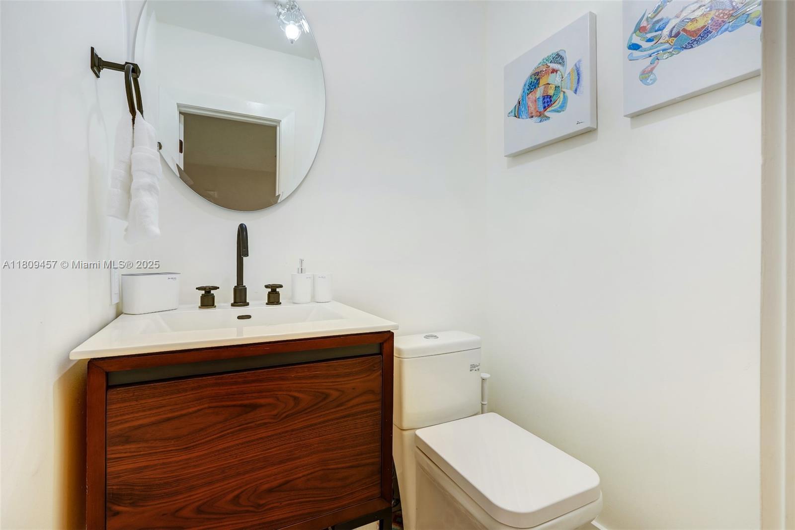 555 Southwest 27th Road Miami, FL 33129 - Photo 25 of 26 a bathroom with a toilet sink and mirror