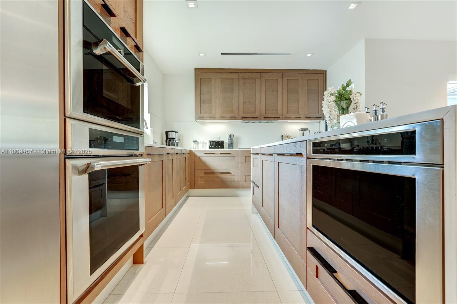 555 Southwest 27th Road Miami, FL 33129 - Photo 10 of 26 a kitchen with stainless steel appliances a stove top oven and cabinets