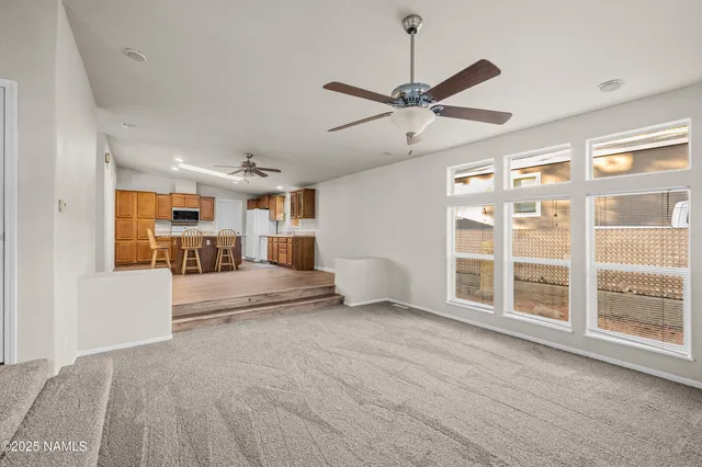 a view of a livingroom with furniture and a ceiling fan