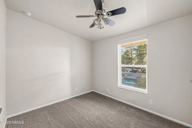 an empty room with closet and windows
