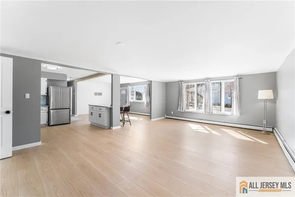 a view of an empty room with window and wooden floor