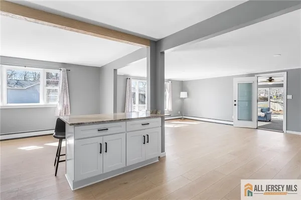 a view of an empty room with window and wooden floor