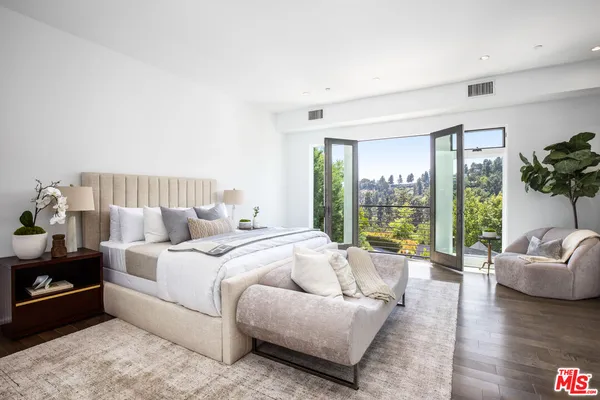a spacious bedroom with a bed and a couch next to a large window