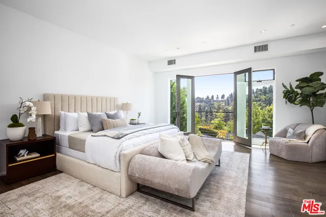 a spacious bedroom with a bed and a couch next to a large window