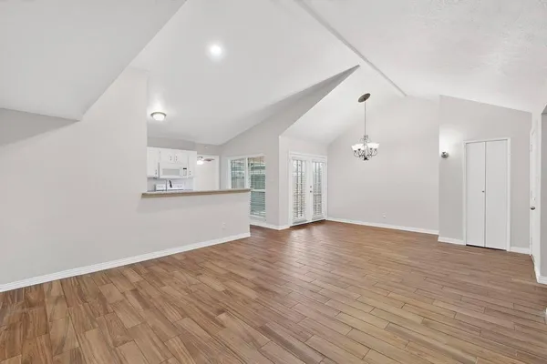 a view of an empty room with wooden floor