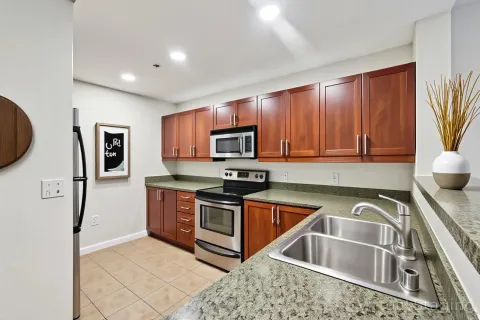 a kitchen with stainless steel appliances granite countertop a sink stove and refrigerator