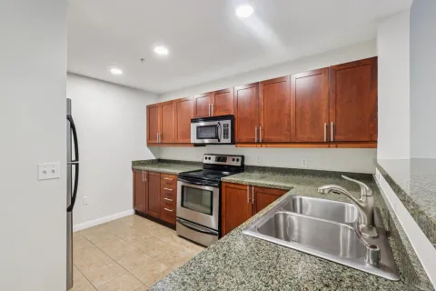 a kitchen with stainless steel appliances granite countertop a sink stove and refrigerator