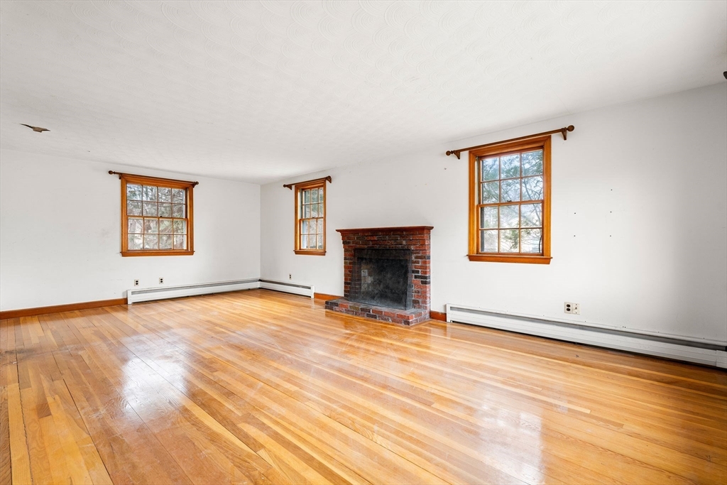 154 Birch Street Braintree, MA 02184 - Photo 6 of 38 a view of empty room with fireplace and wooden floor