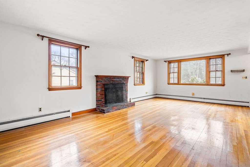154 Birch Street Braintree, MA 02184 - Photo 8 of 38 an empty room with windows fireplace and wooden floor