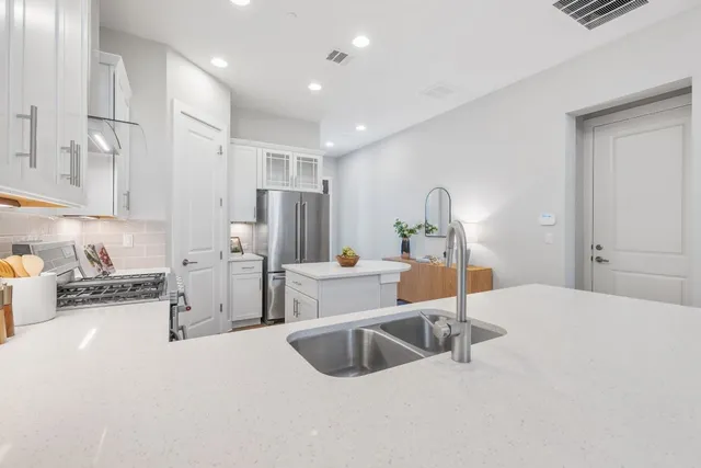 a kitchen with stainless steel appliances a sink and a refrigerator