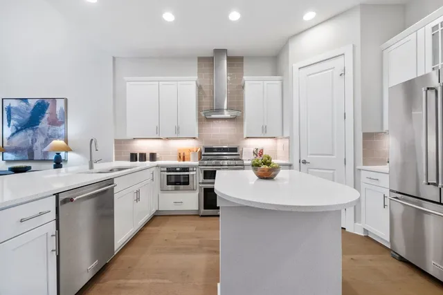 a kitchen with a sink stainless steel appliances and white cabinets