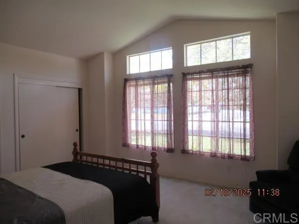 a bedroom with a bed and a lamp on the dresser