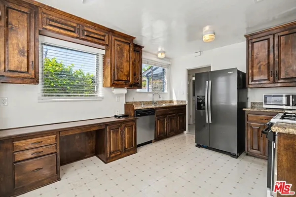a kitchen with stainless steel appliances granite countertop a refrigerator and a sink