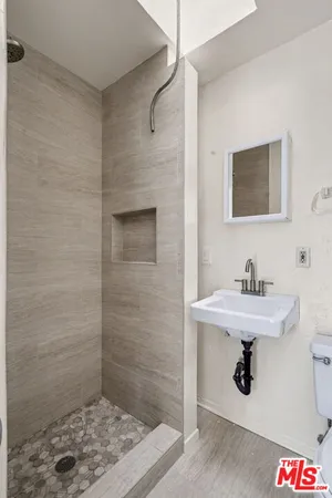 a bathroom with a sink a mirror and shower