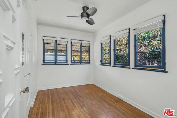 a view of an empty room with a window and wooden floor