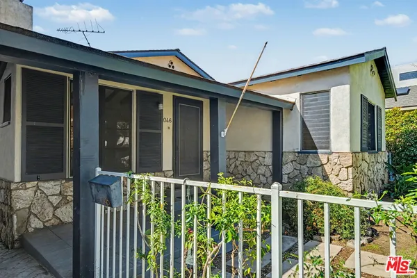 a front view of a house with glass windows and fence