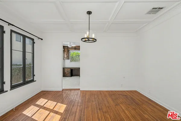 a view of empty room with wooden floor