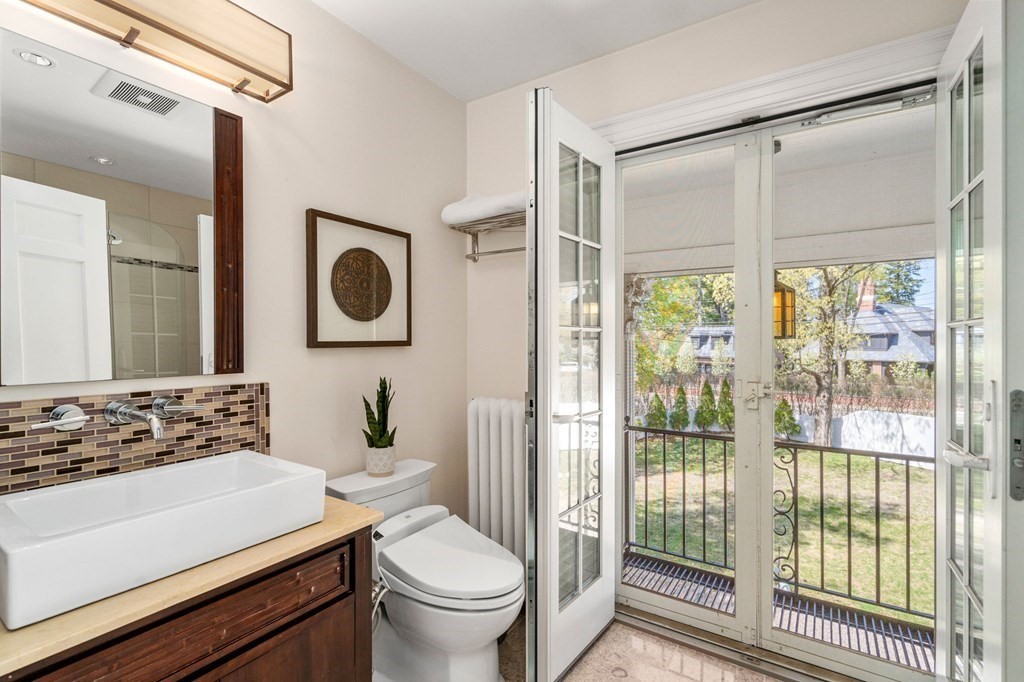 5 Hammond Street Newton, MA 02467 - Photo 33 of 40 a bathroom with a toilet a sink and a large mirror