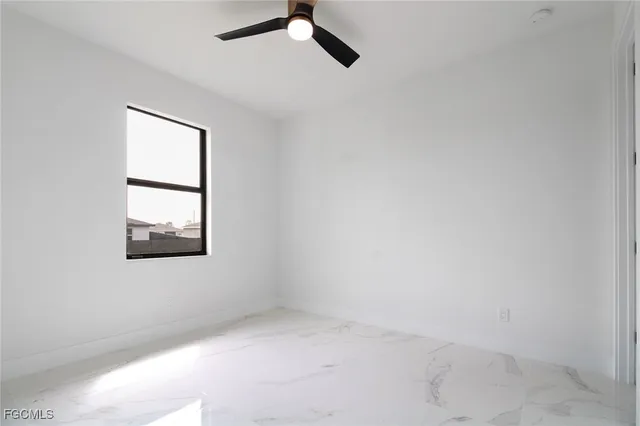 an empty room with a window and a ceiling fan