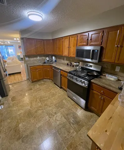 a kitchen with stainless steel appliances granite countertop a stove and a sink