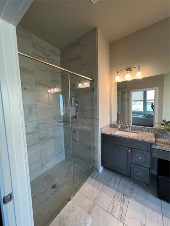 a bathroom with a granite countertop sink mirror and shower