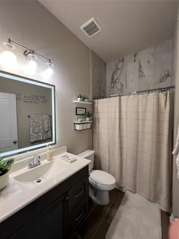 a bathroom with a double vanity sink toilet and a mirror