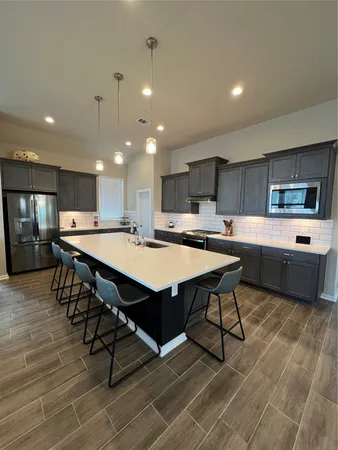 a kitchen with a table chairs sink and cabinets