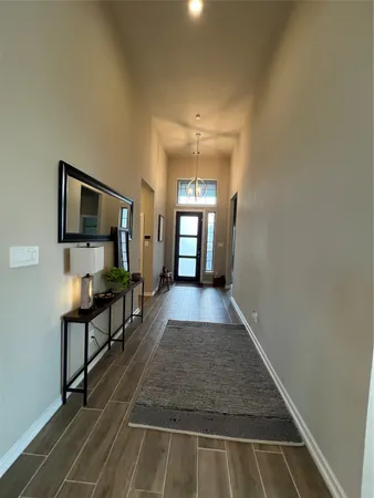 a view of a hallway with wooden floor and furniture