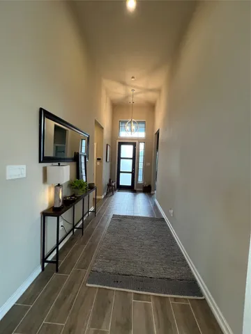 a view of a hallway with wooden floor and furniture
