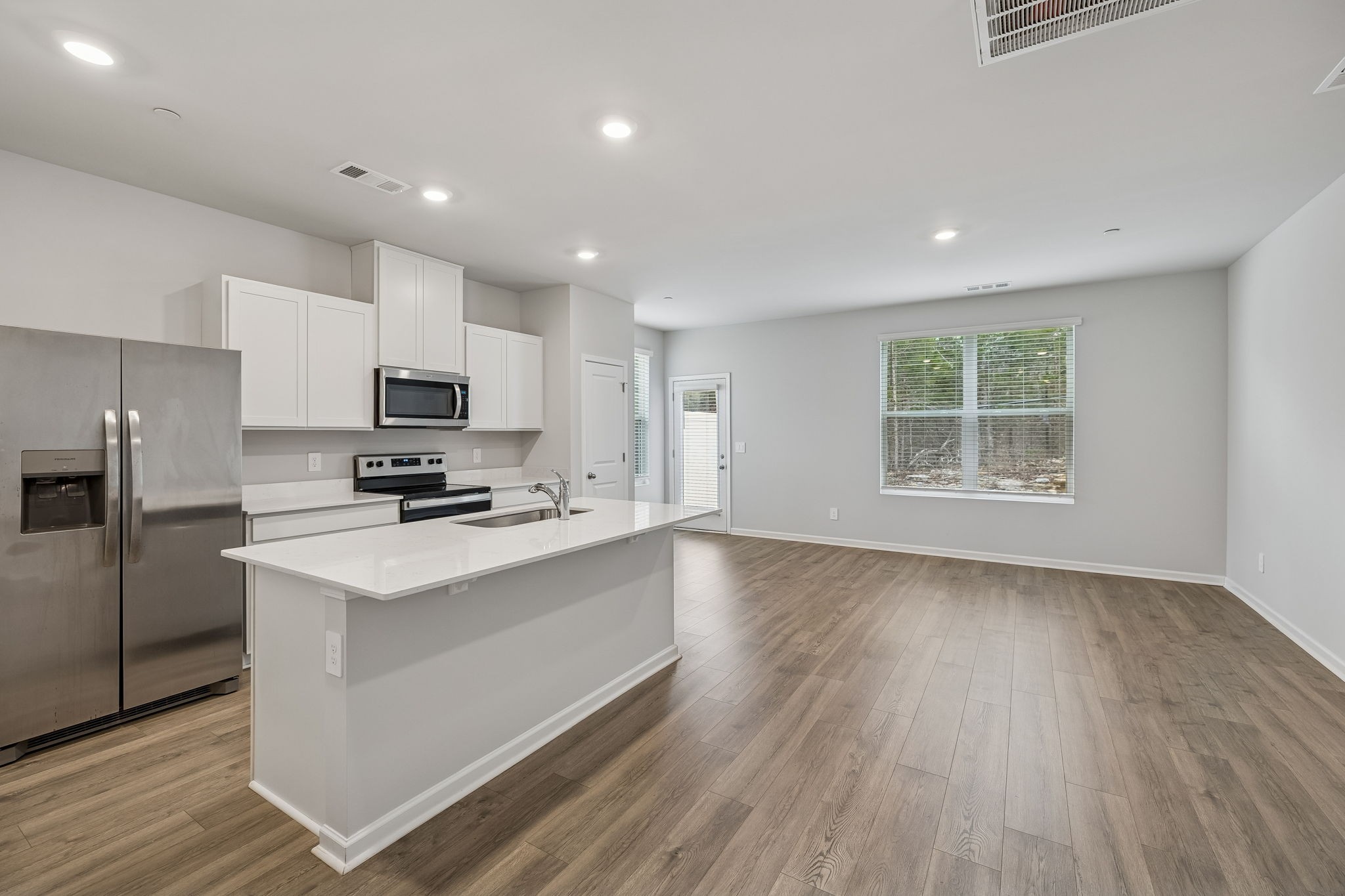 174 Mackenzie Way Lewisburg, TN 37091 - Photo 6 of 32 a kitchen with stainless steel appliances a sink a stove a refrigerator cabinets and a window
