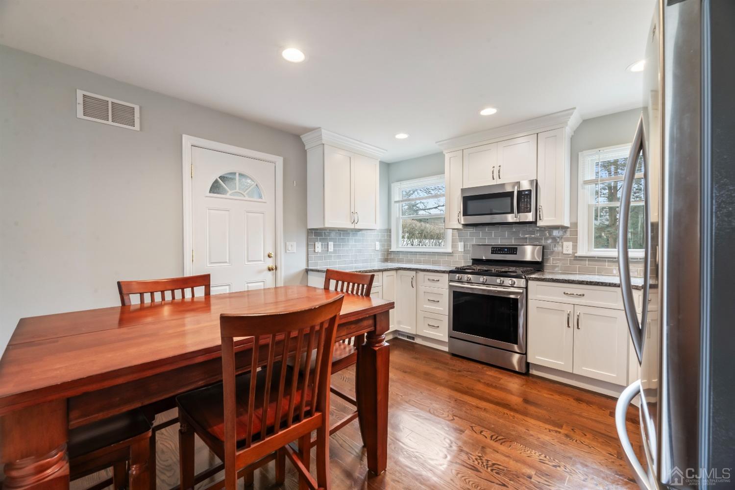 36 Shetland Road East Brunswick, NJ 08816 - Photo 4 of 22 a kitchen with stainless steel appliances a kitchen island hardwood floor sink and stove